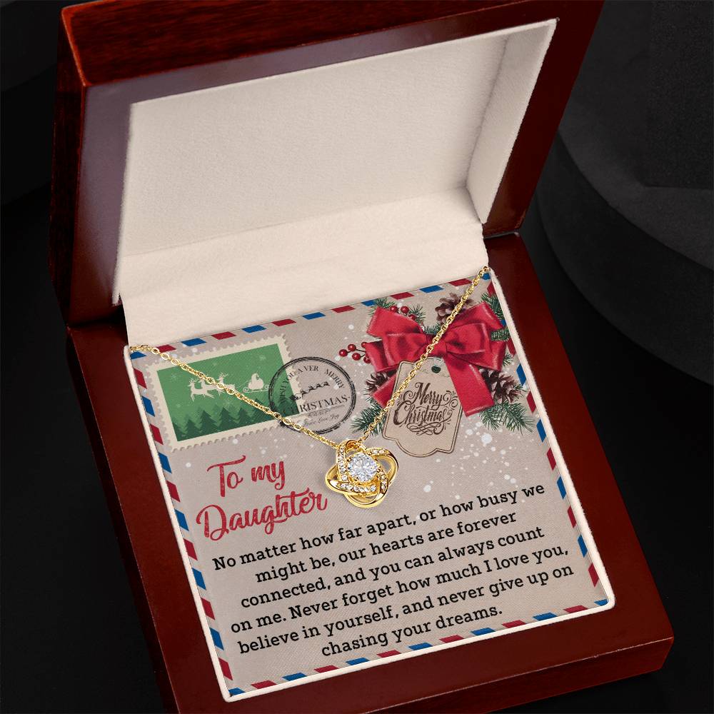 The Daughter-Forever Connected - Love Knot Necklace, presented in a wooden box and embellished with cubic zirconia crystals, comes with a heartfelt message card for a daughter. The package is enhanced with festive decorations and a Christmas stamp, making it an ideal personalized gift for the holiday season.