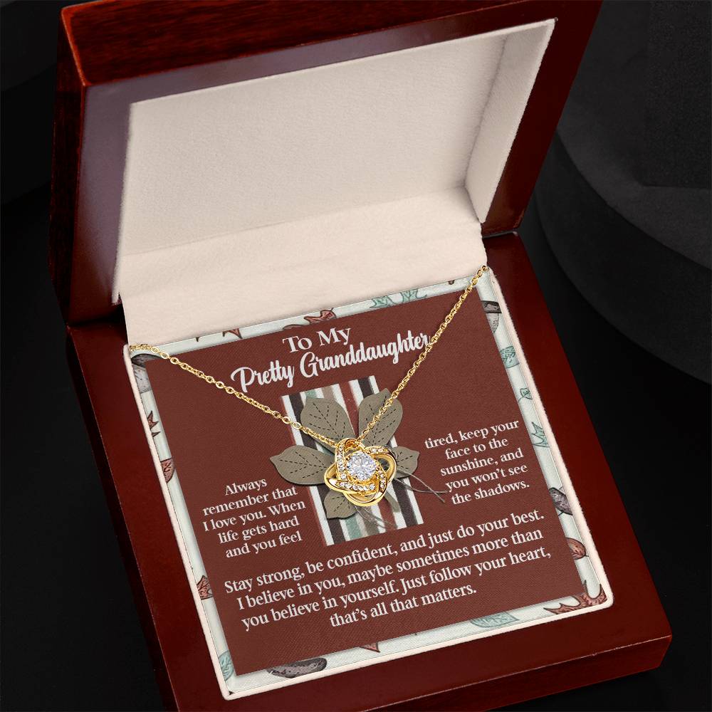 The Granddaughter-See The Shadows - Love Knot Necklace features a floral pendant adorned with cubic zirconia crystals. It is beautifully presented in a box with a heartfelt message for your granddaughter. You can select either a white gold or yellow gold finish to make this gift truly unforgettable.