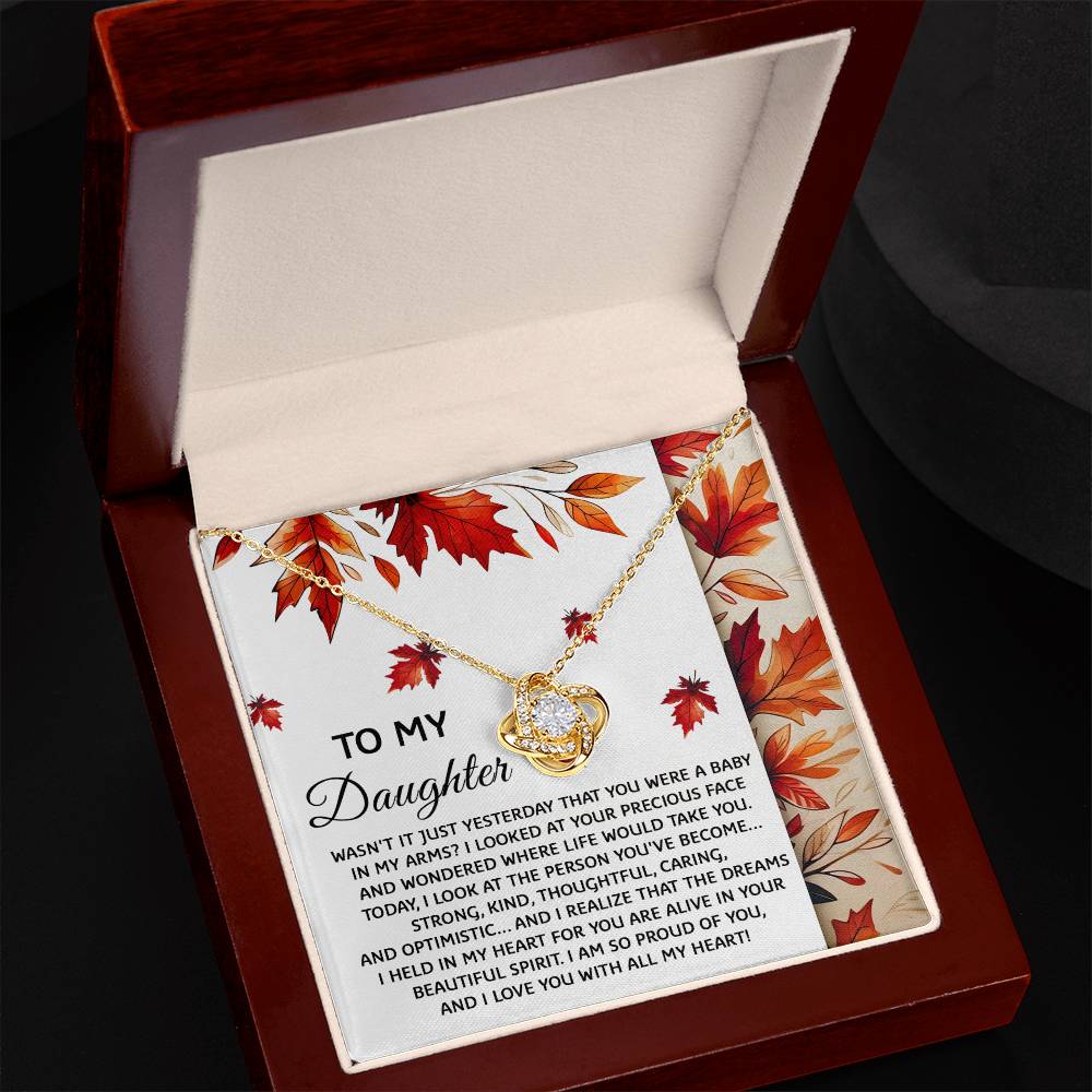 A personalized gift box featuring the "Daughter-Were A Baby - Love Knot Necklace," beautifully adorned with cubic zirconia crystals and accompanied by a heartfelt message expressing pride and love for a daughter.