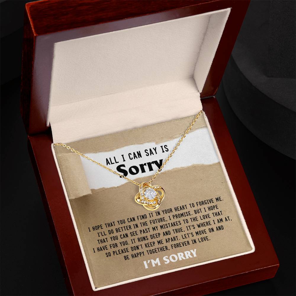 The Sorry-Keep Me Apart - Love Knot Necklace features a gold Love Knot design with a flower pendant, presented in a box adorned with cubic zirconia crystals. Inside the box, you'll find a heartfelt, personalized message expressing sincere apology and a deep desire for forgiveness.