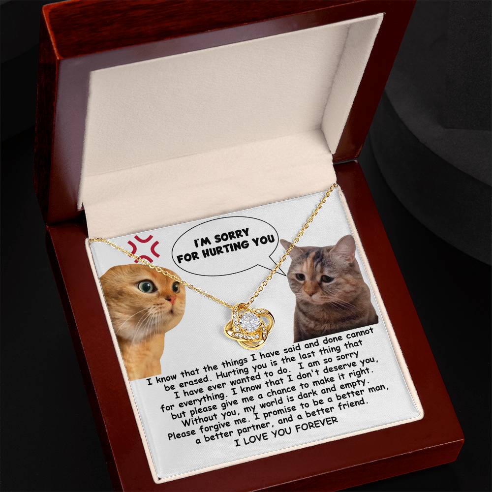The Sorry-Make It Right - Love Knot Necklace showcases a heartfelt note adorned with two cats, one angry and the other sad. The note conveys remorse with the message, "I'm sorry for hurting you," alongside a promise to improve. Enhanced by cubic zirconia crystals and personalized for an intimate touch, it reads "I LOVE YOU FOREVER.