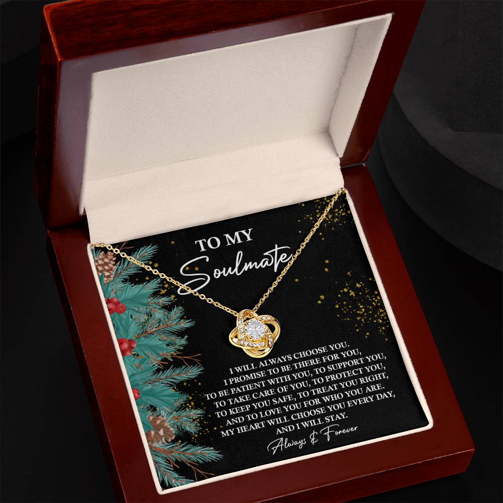 Within a jewelry box is the Soulmate-Treat You Right - Love Knot Necklace, beautifully crafted from 14k white gold over stainless steel with a heart pendant. Accompanying the necklace is a card that reads: "To My Soulmate," enriched with a heartfelt message and enhanced with pine and berry decorations, along with dazzling cubic zirconia crystals.