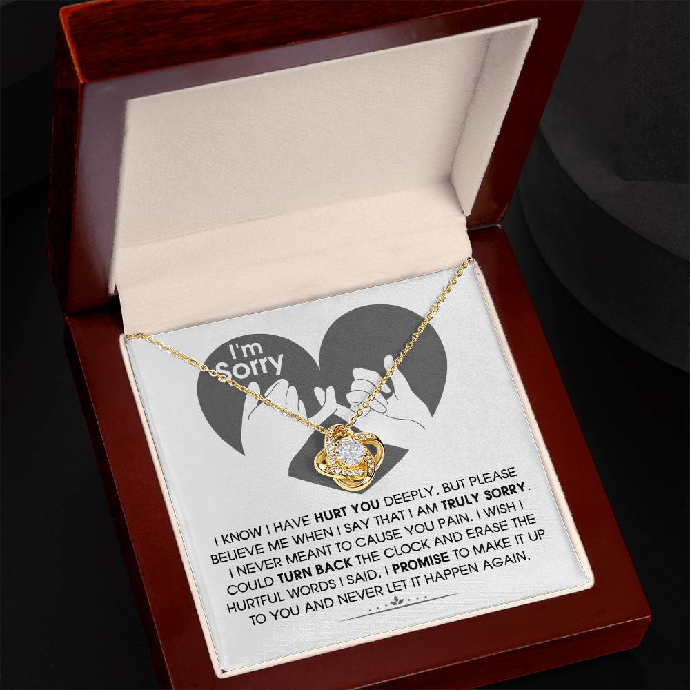 The Sorry-Hurtful Words Love Knot Necklace is displayed on a card featuring an illustration of a heart and hands. The card conveys an apology message that expresses deep regret and a promise to make amends. This personalized gift is adorned with cubic zirconia, symbolizing the depth of sincerity and commitment.