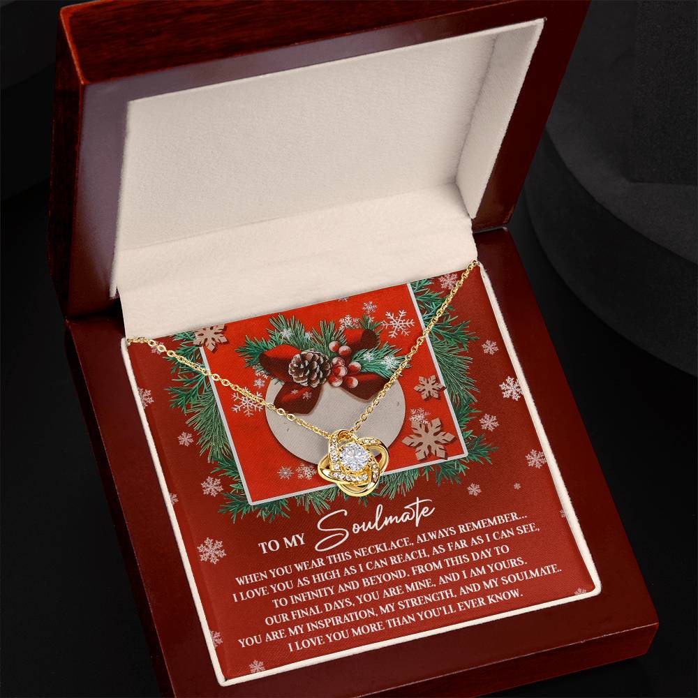 The timeless gift of the "Soulmate-I Am Yours - Love Knot Necklace" is beautifully presented in a box. It is accompanied by a festive card decorated with pinecones, berries, and snowflakes, perfectly capturing love and appreciation for a soulmate.