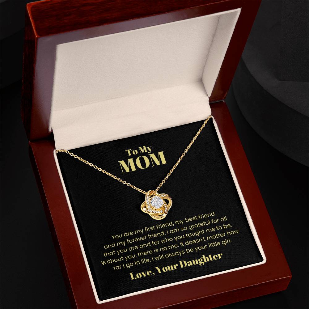 The "To My Mom, You Are My First Friend - Love Knot Necklace" comes in a red and black jewelry box and features a heart-shaped pendant adorned with cubic zirconia crystals. This necklace, available in either white gold or yellow gold finish, includes a heartfelt message from "Your Daughter" to "Mom," expressing love and gratitude.