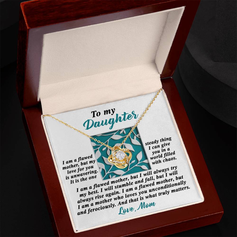 A jewelry box containing a stunning Daughter-Stumble And Fall - Love Knot Necklace adorned with cubic zirconia crystals. The inside of the box lid has a personalized inscription that begins with "To my Daughter" and ends with "Love, Mom.