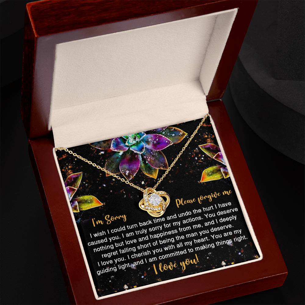 The Sorry-All My Heart - Love Knot Necklace features an interlocking heart pendant on a card with vibrant succulent graphics and the message: "I'm Sorry, Please forgive me. I love you." Adorned with sparkling cubic zirconia crystals, this necklace is available in a choice of white gold or yellow gold finish.