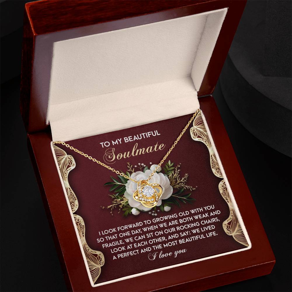 The Soulmate-Rocking Chairs - Love Knot Necklace showcases interlocking hearts with sparkling cubic zirconia crystals. It comes in an open box with a heartfelt message addressed to "My Beautiful Soulmate" about growing old together, making it the perfect personalized gift.