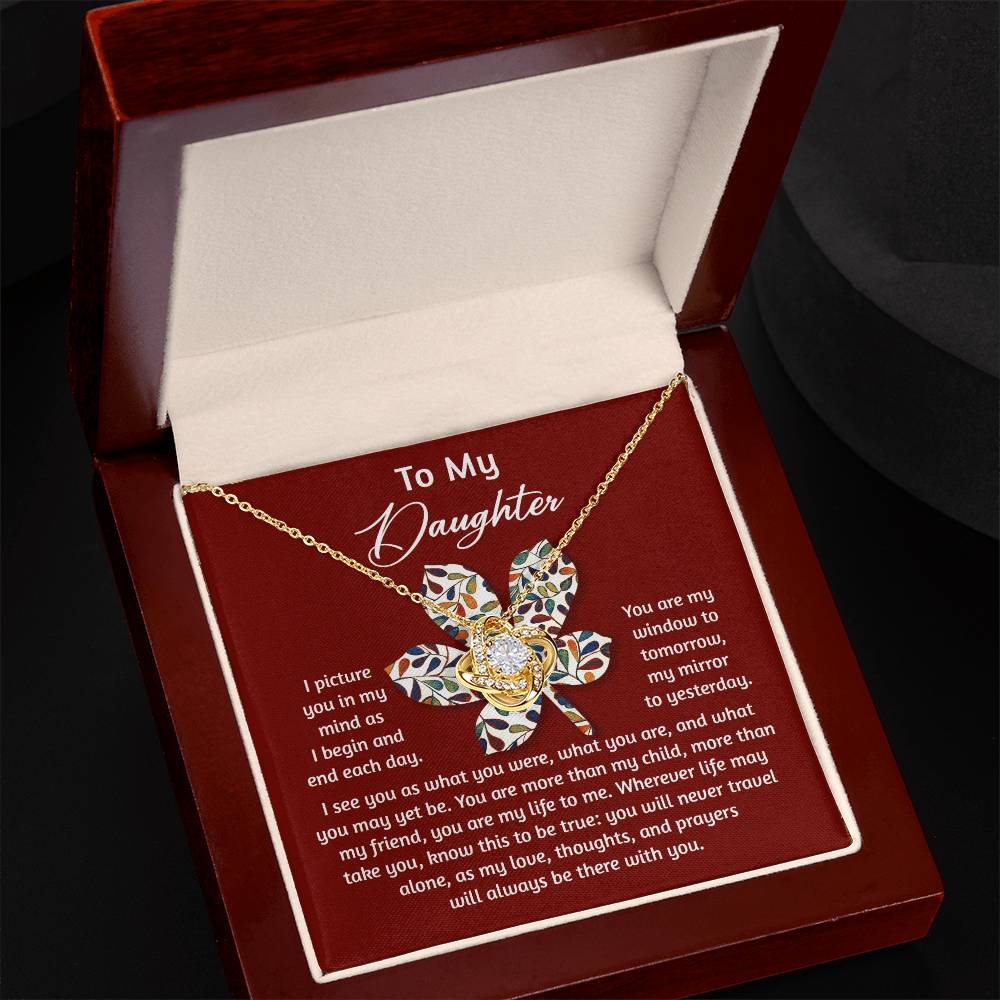 The Daughter-To Be True - Love Knot Necklace features a gold design with a flower pendant embellished with cubic zirconia crystals, presented in an elegant red jewelry box. Inside, a heartfelt message reads "To My Daughter," making it the ideal gift for your loved one.