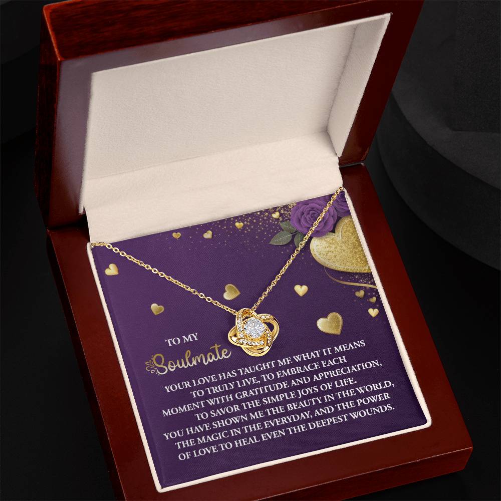 The Soulmate-Joys Of Life - Love Knot Necklace, with its gold heart pendant and sparkling cubic zirconia, is beautifully displayed in a jewelry box lined with roses and hearts. It features a heartfelt message about love and soulmates—a perfect personalized gift for someone special.
