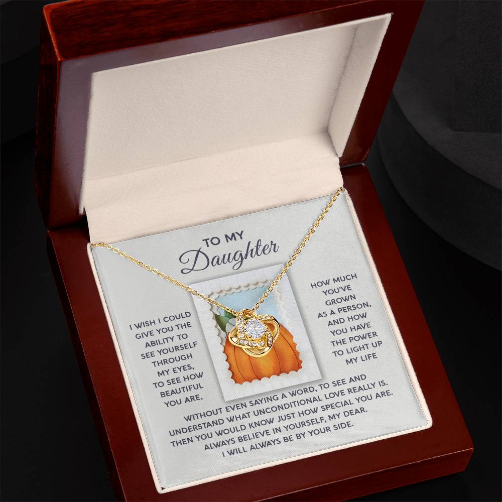 A Daughter-How Special - Love Knot Necklace with a pendant is elegantly presented in a jewelry box. Inside, there is a touching message titled "To My Daughter," conveying love and support. Embellished with shimmering Cubic Zirconia, this personalized gift beautifully symbolizes your eternal bond.