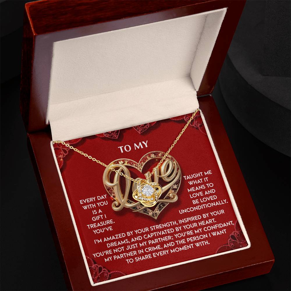 The My Love-Every Moment - Love Knot Necklace, with its gold heart shape and cubic zirconia crystals, is beautifully presented in a jewelry box and comes with a red and white card featuring a love message.