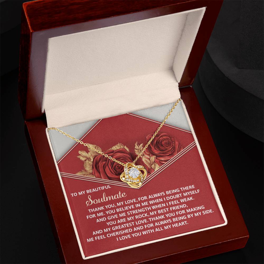 An open jewelry box reveals the Soulmate-All My Heart - Love Knot Necklace with a heart-shaped pendant, shimmering with cubic zirconia crystals. Inside the lid, a red card decorated with roses conveys a heartfelt message about love and gratitude.