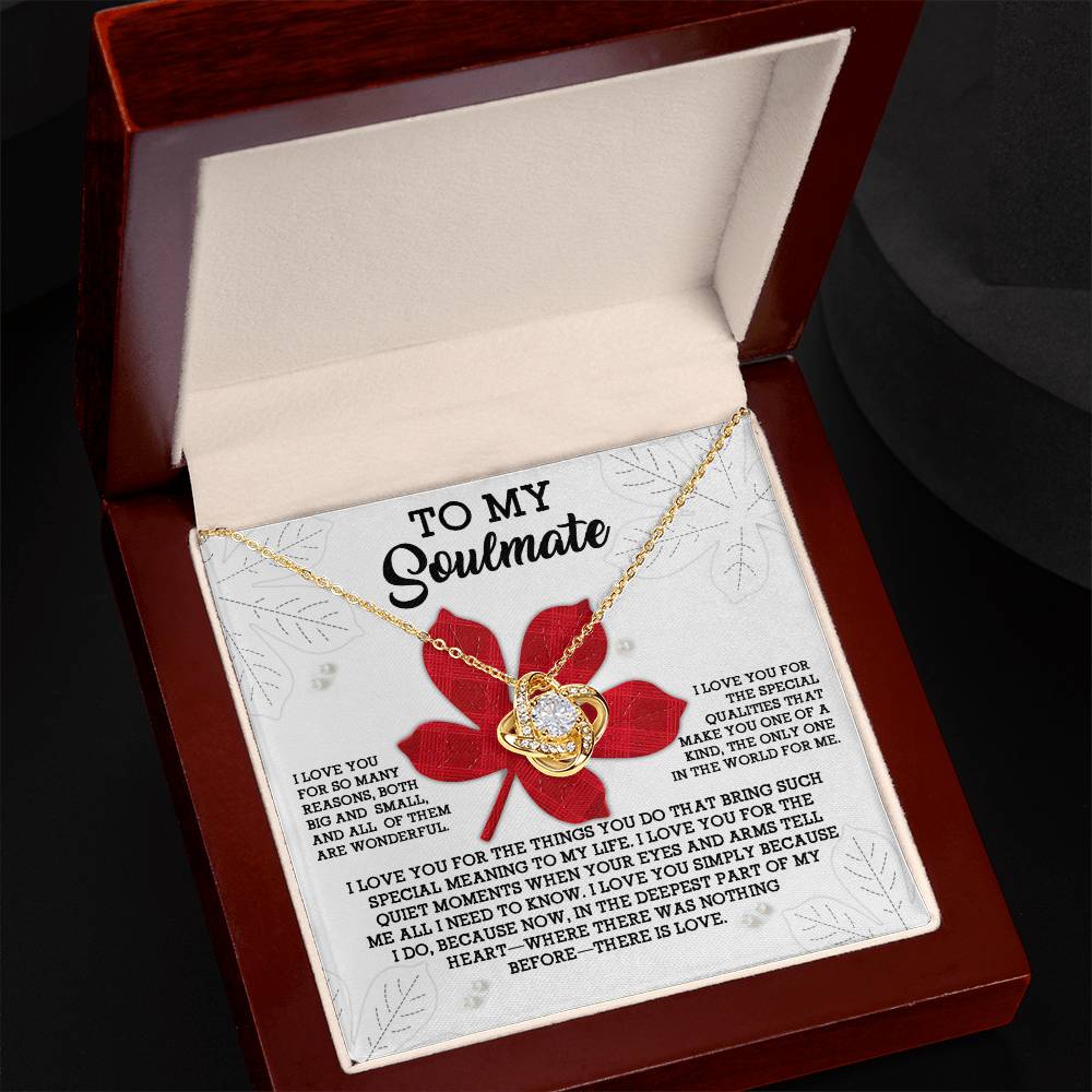 The "Soulmate-There Is Love - Love Knot Necklace" features a heart-shaped pendant encrusted with premium cubic zirconia crystals, set in 14k white gold. It comes nestled in a jewelry box accompanied by a romantic message addressed "To My Soulmate.