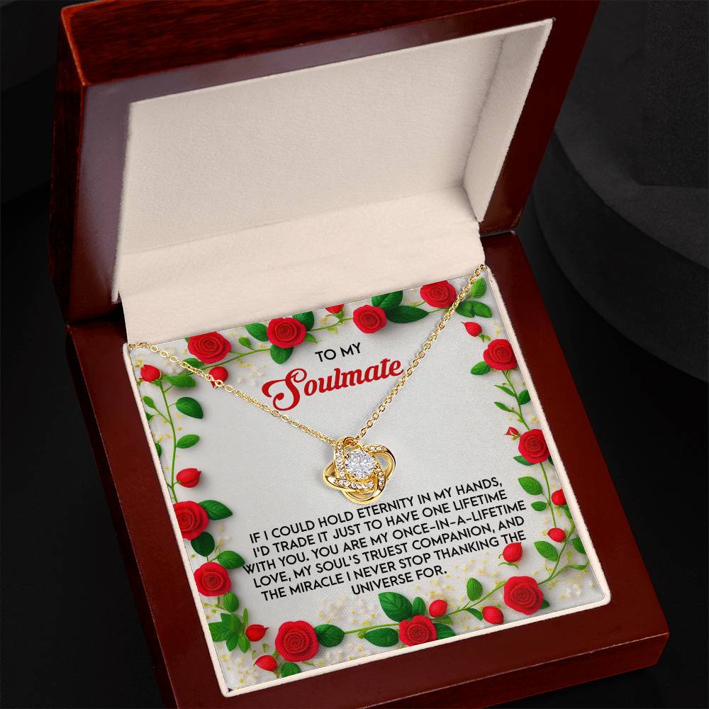 The Soulmate-One Lifetime - Love Knot Necklace in white gold comes nestled in a wooden box with a heartfelt soulmate message and is adorned with red roses. Its shimmering cubic zirconia adds an elegant touch to this romantic treasure.