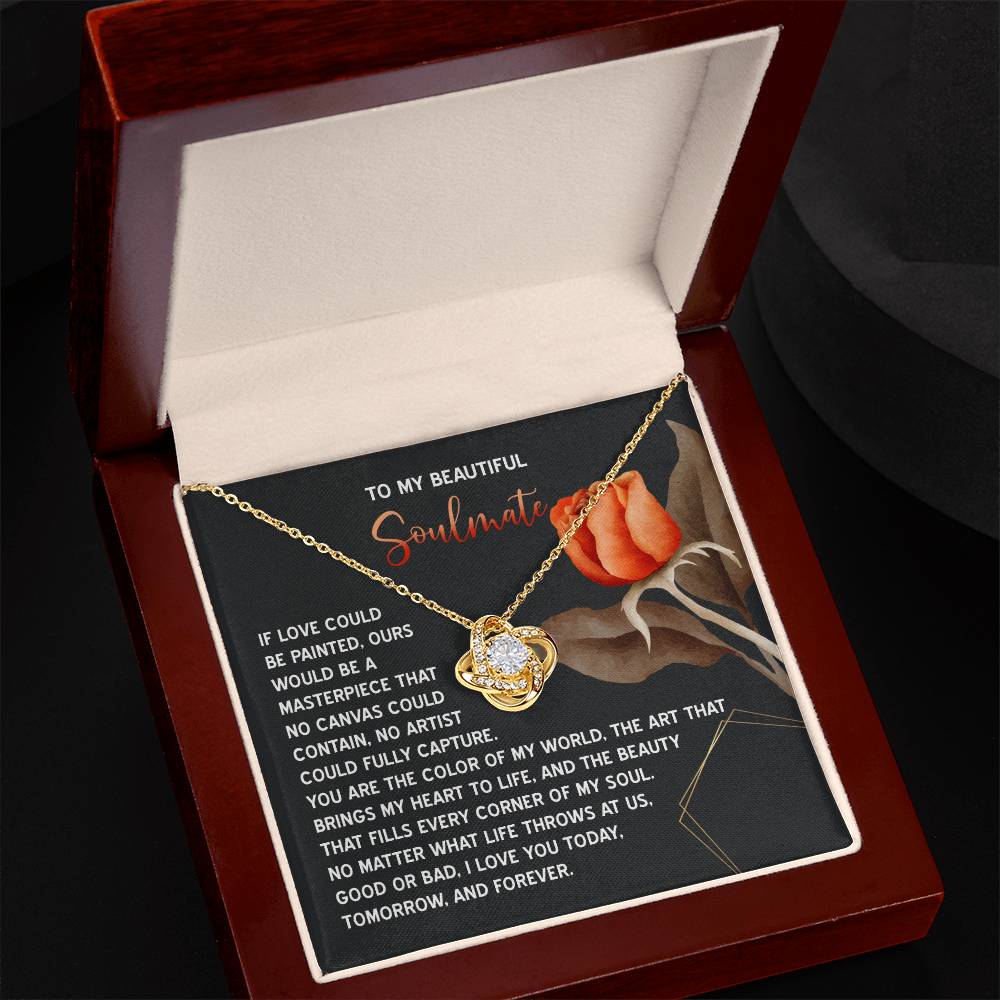 The Soulmate-A Masterpiece - Love Knot Necklace features intertwined hearts adorned with cubic zirconia crystals in a red gift box, nestled on a card decorated with an orange rose and a romantic message, making it the perfect personalized gift for cherished connections.