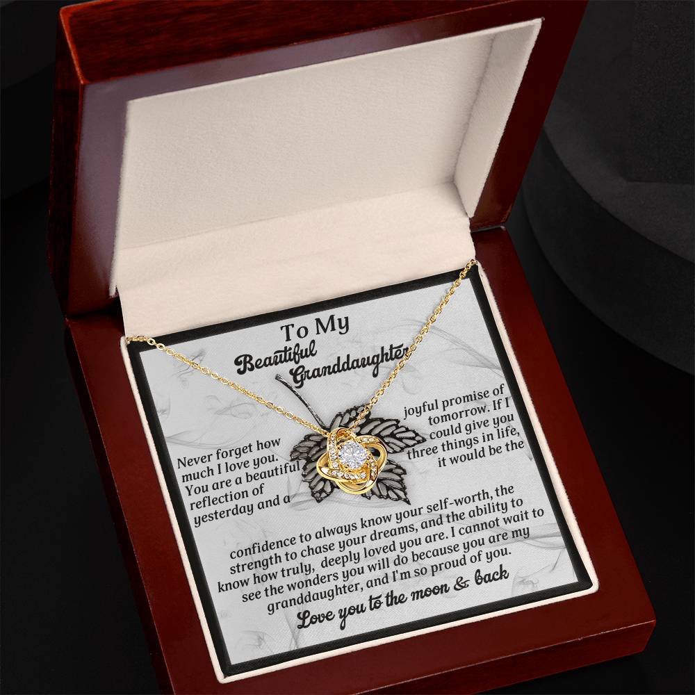 The Granddaughter-Deeply Loved Love Knot Necklace features a lovely heart pendant in gold, elegantly presented in a wooden gift box, complete with a heartfelt message for your granddaughter.