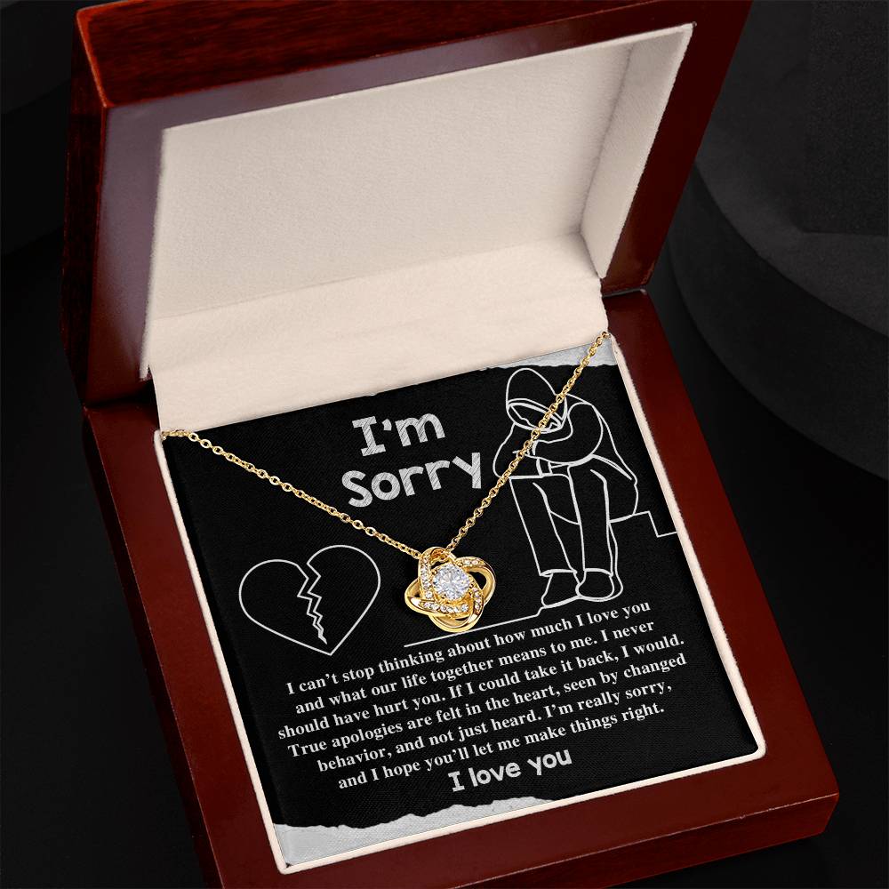 The Sorry-Not Just Heard - Love Knot Necklace is elegantly presented in a box adorned with premium cubic zirconia crystals, featuring a heartfelt apology message alongside an image of a broken heart and a person sitting with their head down. The text conveys regret for past actions and reaffirms ongoing love, making it the perfect personalized gift.