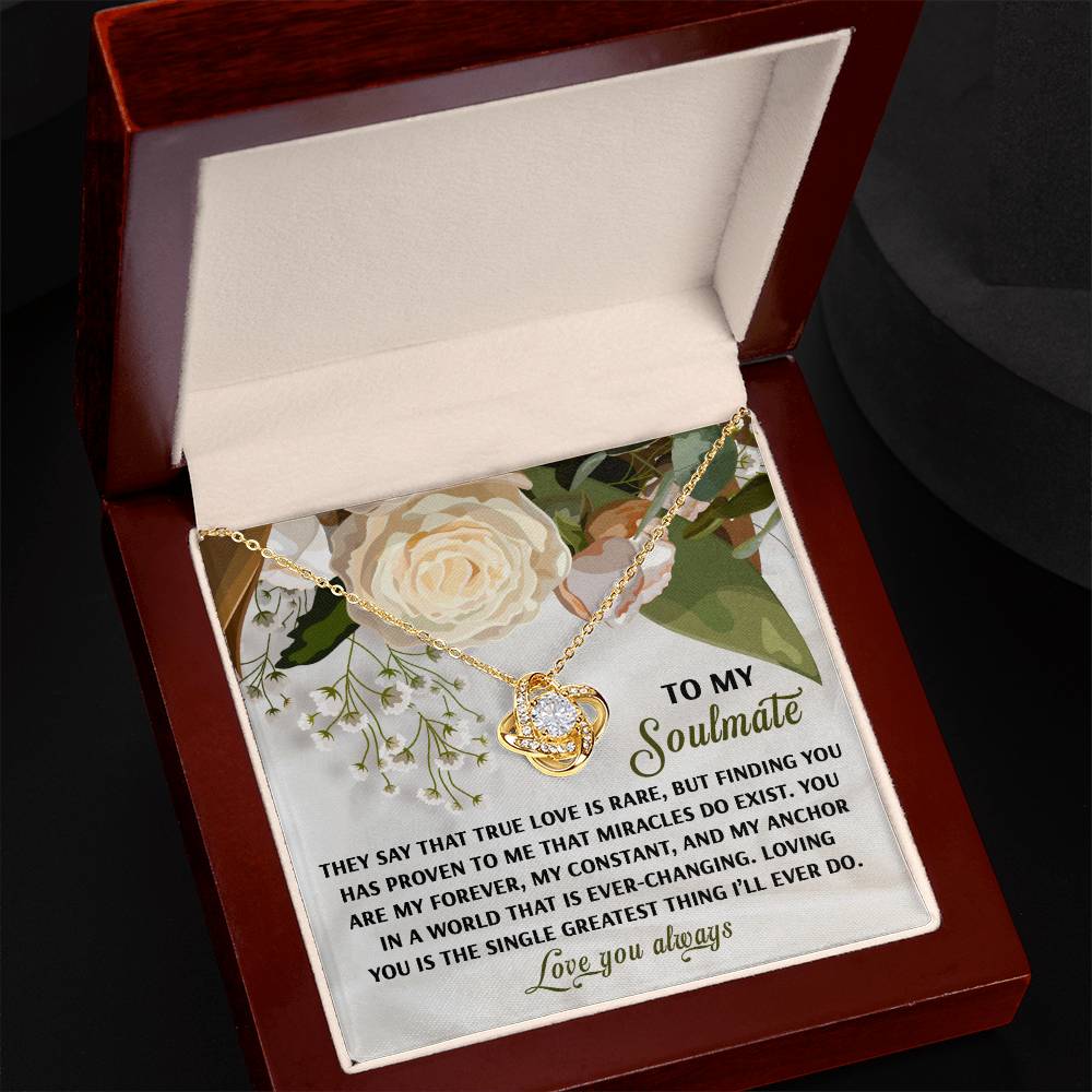 The Soulmate-Greatest Thing - Love Knot Necklace, featuring sparkling cubic zirconia crystals, is showcased in a floral-themed jewelry box. With an inscription about love and soulmates, it makes an ideal personalized gift for someone special.