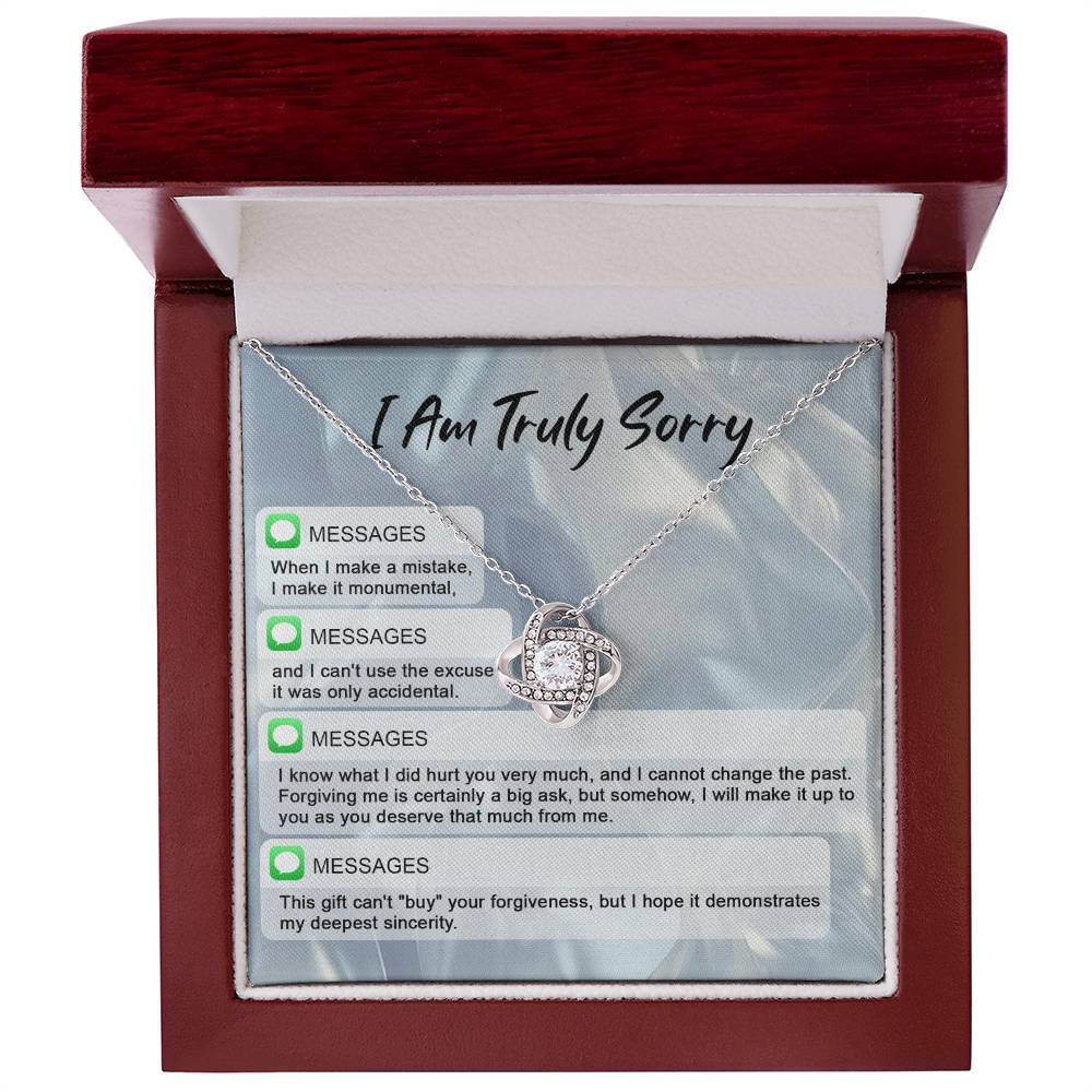 The "Sorry, Make A Mistake - Love Knot Necklace" adorned with cubic zirconia crystals, placed over a background card that reads "I Am Truly Sorry" and includes a series of apology text messages, is the perfect personalized gift for heartfelt apologies.