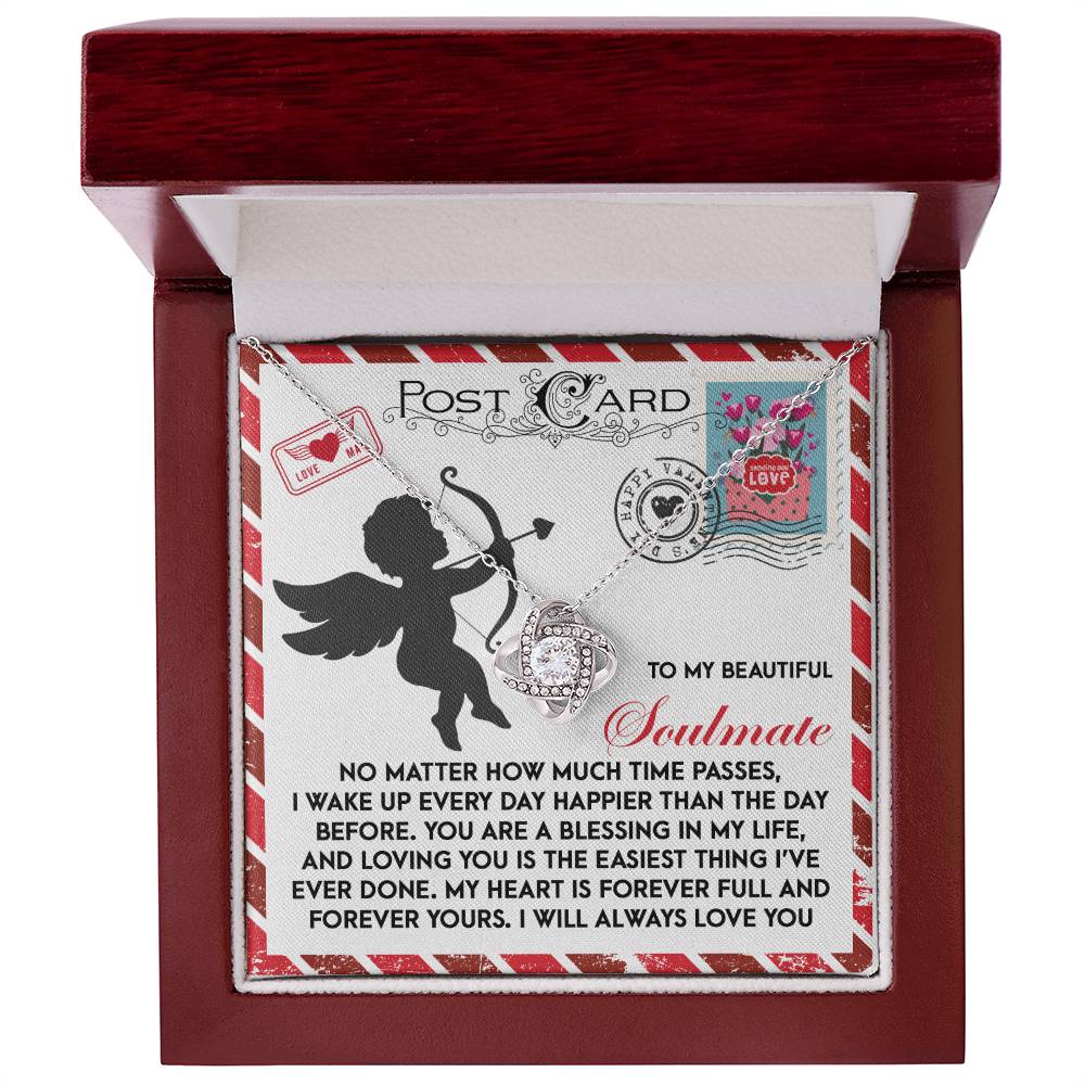 The Soulmate-Forever Yours - Love Knot Necklace, featuring a heart pendant, is housed in a box with a lid that reveals a romantic message for "Soulmate," adorned with cupid, hearts, and stamp images to symbolize an unbreakable bond.