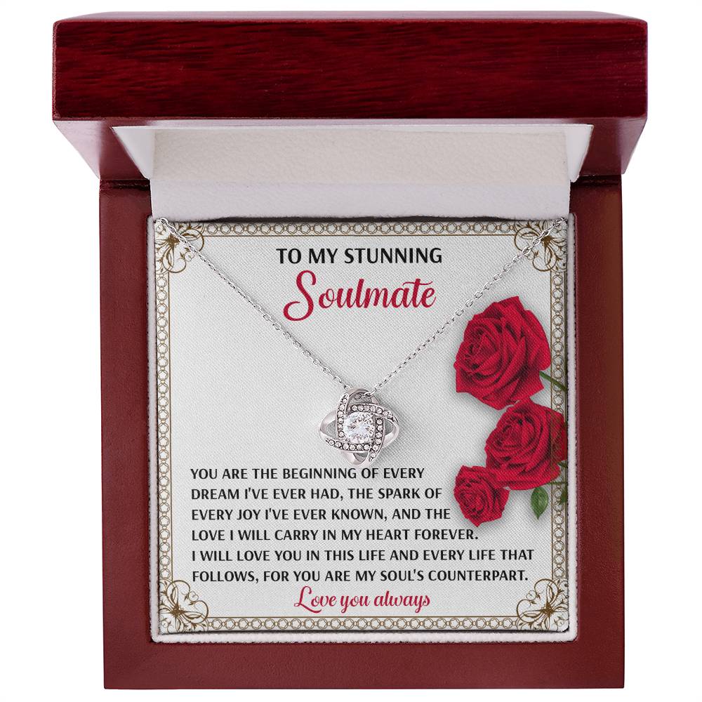 A jewelry box contains a Soulmate-Soul_s Counterpart Love Knot Necklace with a gold finish. Inside, a romantic message and red roses say, "To my stunning soulmate... Love you always.