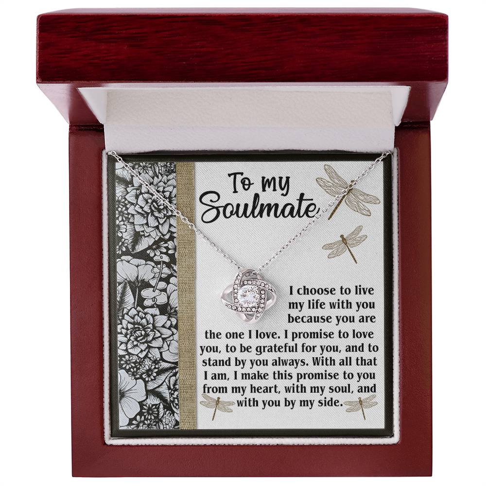 A Soulmate-Make This Promise - Love Knot Necklace, featuring a heart and infinity symbol pendant, is displayed in a box. The lid of the box, adorned with sparkling cubic zirconia crystals, has a message titled "To my Soulmate" followed by a heartfelt promise of love and commitment.