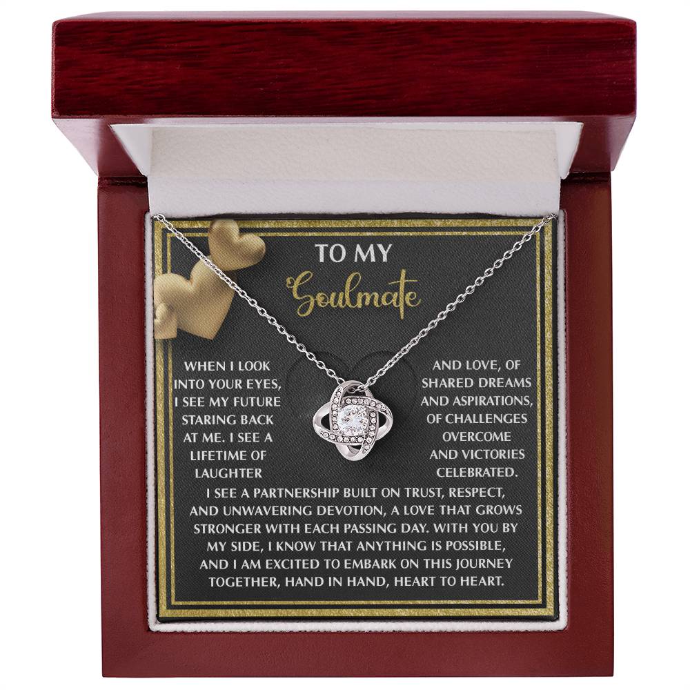 The Soulmate-Heart To Heart - Love Knot Necklace, featuring an infinity design in a red velvet-lined box, is adorned with cubic zirconia crystals. A "To My Soulmate" card with heart graphics enhances this unique gift's presentation.