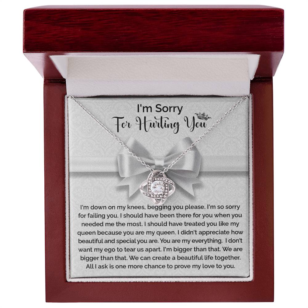 The "Sorry-My Queen - Love Knot Necklace" features a knot-shaped pendant adorned with cubic zirconia crystals and comes in a gift box that includes an apology message, expressing regret and asking for forgiveness and another chance to prove love.