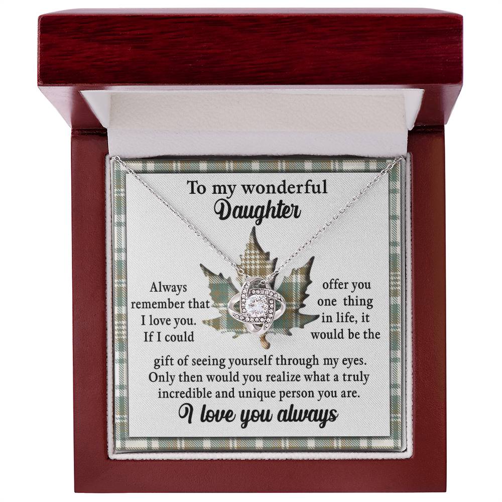 The Daughter-Through My Eyes - Love Knot Necklace in 14k white gold rests inside a wooden box with a message that reads: "To my wonderful daughter, always remember that I love you. I love you always." Adorned with cubic zirconia crystals, the necklace is set against a background featuring a delicate leaf design.