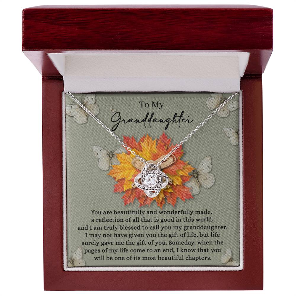 The Granddaughter-Gift Of You - Love Knot Necklace, featuring a heart pendant and sparkling cubic zirconia crystals, is beautifully showcased in an open box with a touching message for your granddaughter.