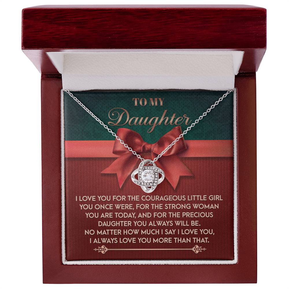 Displayed in an open box with a heartfelt inscription dedicated to a daughter, the Daughter-Always Will Be - Love Knot Necklace features a shimmering pendant adorned with cubic zirconia crystals. It offers an elegant choice between a white gold or yellow gold finish.