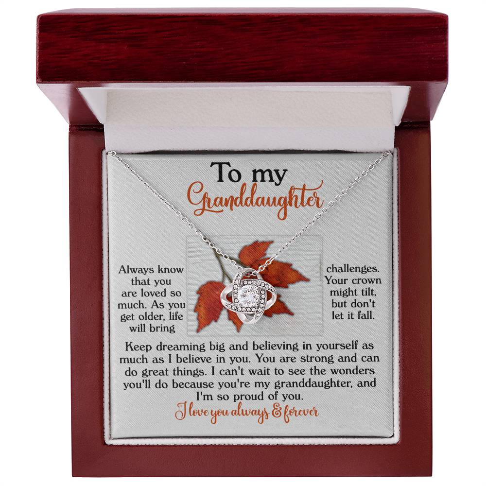 Granddaughter-Do Great Things - Love Knot Necklace with a gold finish and cubic zirconia crystals, accompanied by a heartfelt message card expressing love, strength, and encouragement with the words: "To my Granddaughter.