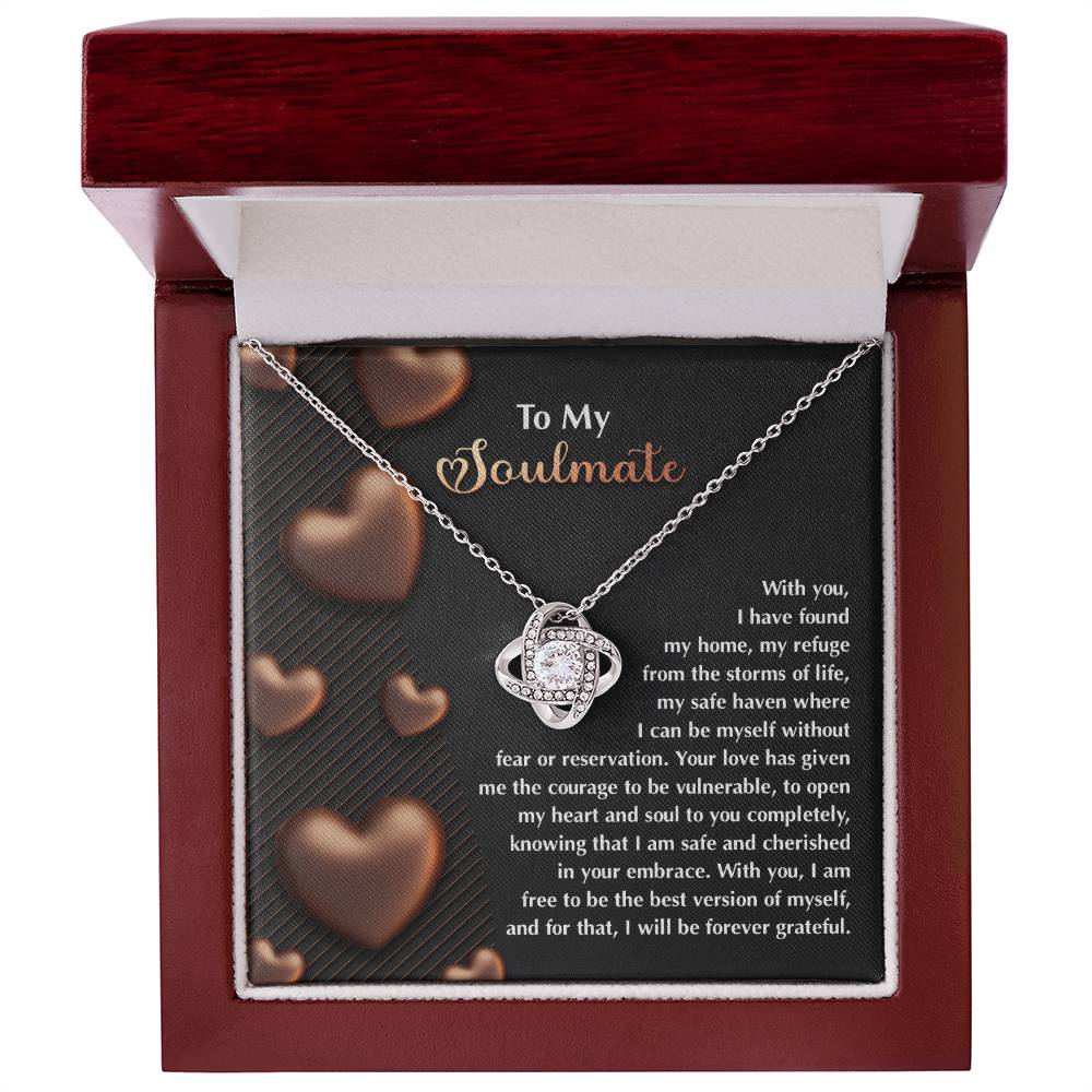 The Soulmate-Best Version Love Knot Necklace rests in a box decorated with sparkling cubic zirconia crystals and comes with a heartfelt message, accented by heart decorations on the background card.