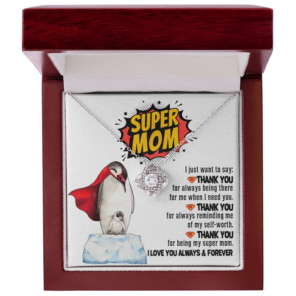 The "To Mom, Super Mom - Love Knot Necklace" comes in a box with a heart-shaped pendant. The inner lid showcases an illustration of a penguin with its chick along with a message of gratitude to a "Super Mom" for her unwavering support and love, emphasizing the unbreakable bond between them.