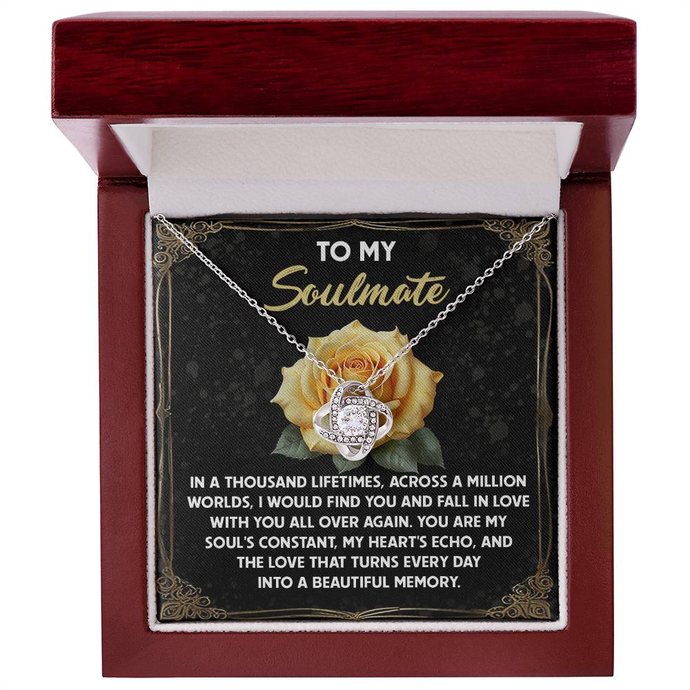 The Soulmate-Beautiful Memory - Love Knot Necklace, in a red jewelry box, features intertwined heart and ring pendants with cubic zirconia. The box lid has a yellow rose design and a soulmate message, making it an ideal personalized gift.