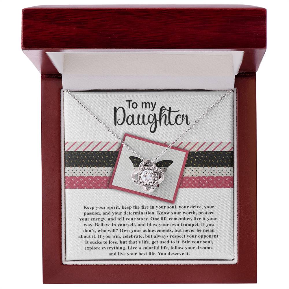The Daughter-Keep The Fire - Love Knot Necklace with a butterfly pendant sits in an open red box. Adorned with cubic zirconia crystals, the box lid features a "To my Daughter" message, followed by an inspirational paragraph. This makes for a heartfelt personalized gift.
