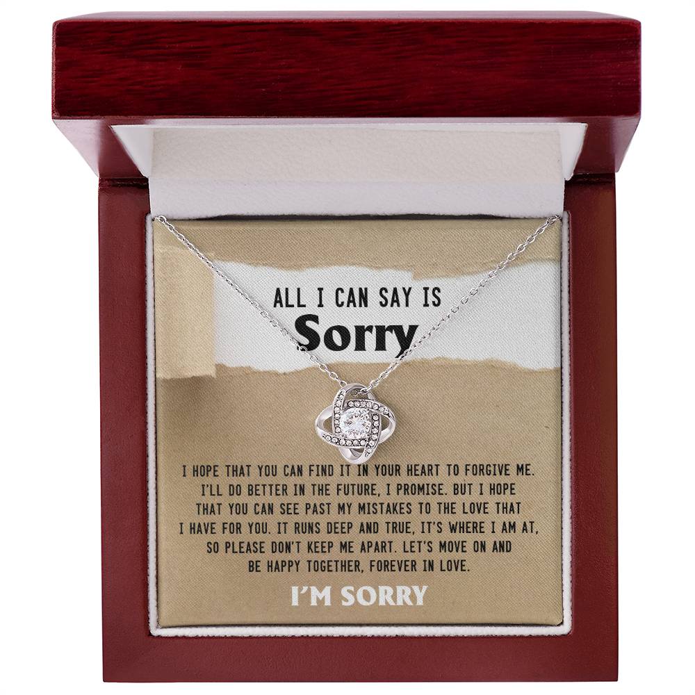 The Sorry-Keep Me Apart - Love Knot Necklace, featuring an interlocking circle pendant encrusted with cubic zirconia crystals, is elegantly presented in a wooden box. Inside, an apology note expresses heartfelt remorse and a promise to improve, while the cover poignantly reads "All I can say is sorry," making it a truly personalized gift.