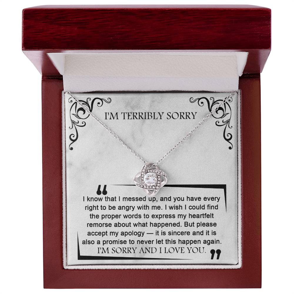 The Sorry-Angry With Me - Love Knot Necklace, presented in a wooden box with an apology note inscribed inside, features sparkling cubic zirconia crystals against a white gold finish. The note expresses regret and promises not to repeat the mistake, concluding with "I'M SORRY AND I LOVE YOU.