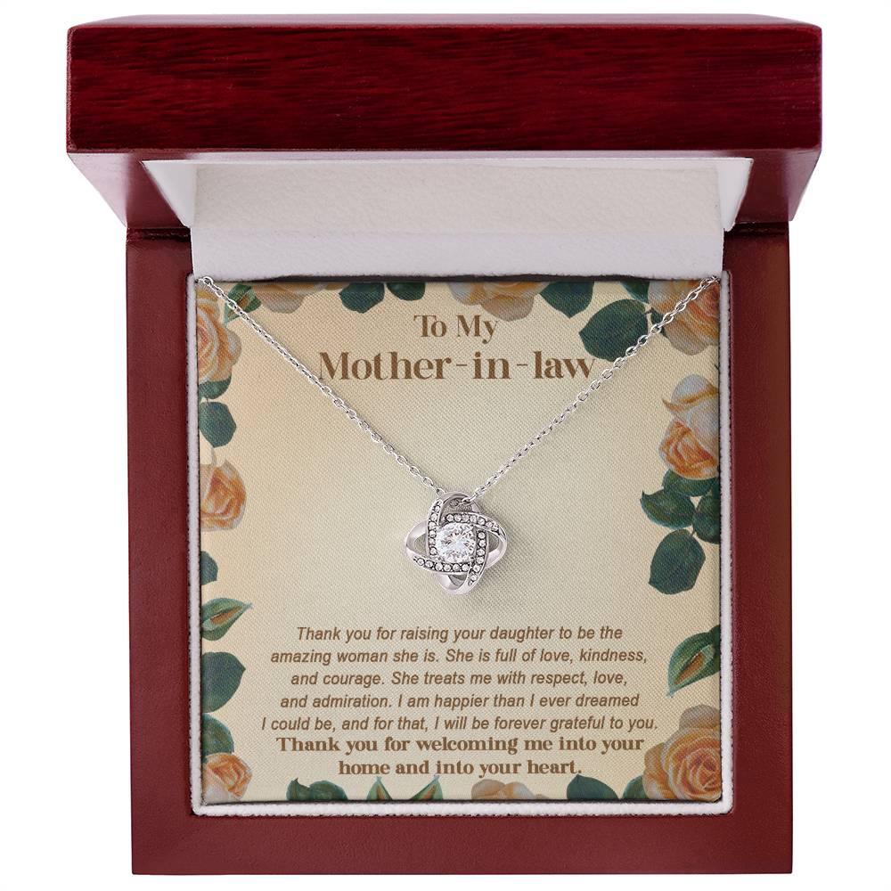 A "To Mother-in-law, Grateful To You - Love Knot Necklace" adorned with cubic zirconia crystals is showcased in an open wooden jewelry box, featuring an inscription that expresses gratitude for a mother-in-law's love, kindness, and acceptance. This personalized gift embodies heartfelt appreciation.