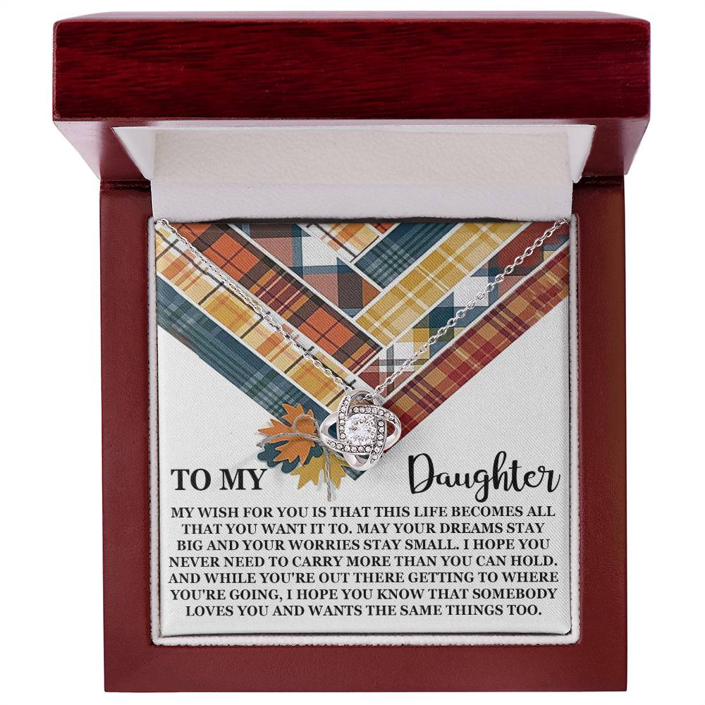 The "Daughter-The Same Things - Love Knot Necklace" jewelry box features a heartfelt message to a daughter, surrounded by a vibrant plaid pattern. Inside, it presents a stunning Love Knot Necklace adorned with cubic zirconia crystals, available in both white gold and yellow gold finishes.