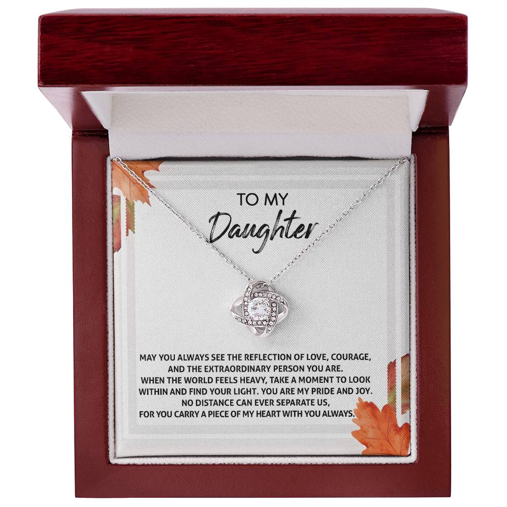 The Daughter-Find Your Light - Love Knot Necklace comes in a red box, adorned with shimmering cubic zirconia crystals and a refined white gold finish. The message reads, "To My Daughter. May you always see the reflection of love, courage, and the extraordinary person you are.