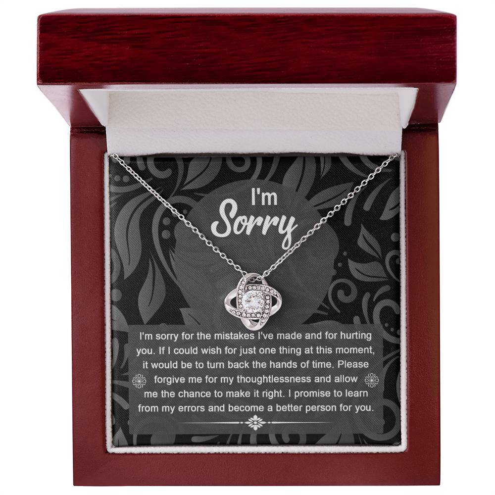 The Sorry-Just One Thing - Love Knot Necklace with intertwined loops is elegantly displayed in a box, featuring an apology message on the inside lid that reads: "I'm sorry. I'm sorry for the mistakes I've made and for hurting you...