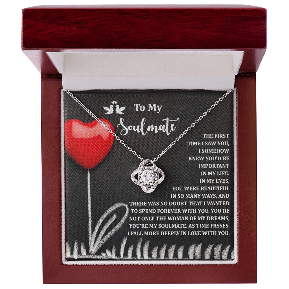 The Soulmate-Forever With You - Love Knot Necklace, featuring interlocking rings in white gold and sparkling cubic zirconia crystals, comes in a red jewelry box with a heartfelt message card for your soulmate, beautifully adorned with a red heart and floral design.