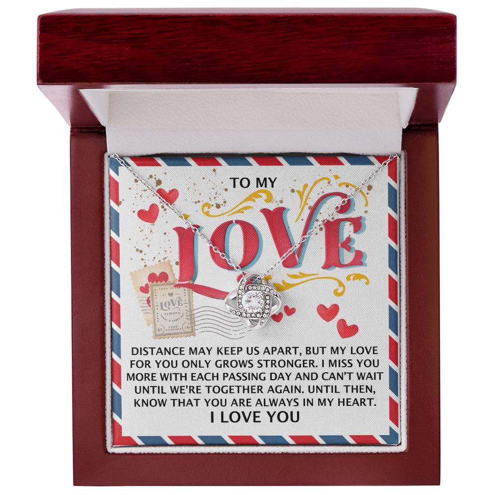 The Soulmate-In My Heart Love Knot Necklace features intertwined rings, sparkling cubic zirconia crystals in 14k white gold, nestled in a red box with "To My Love" on the lid, conveying affection and longing.