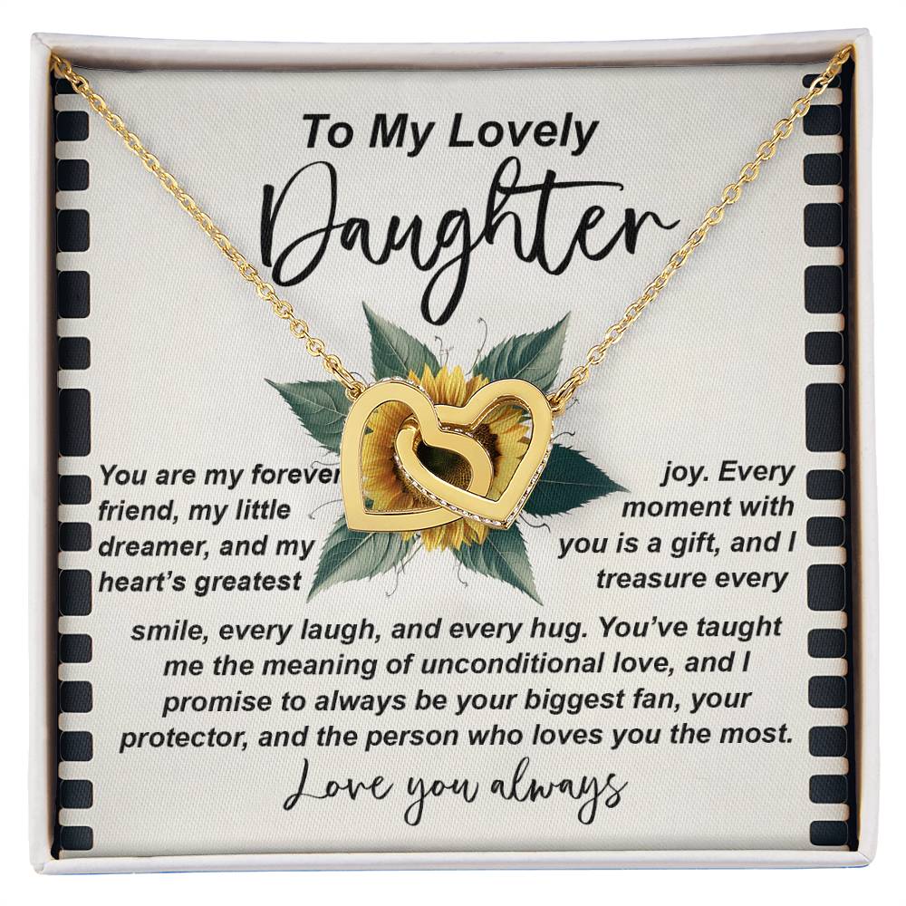 The Daughter-Little Dreamer Interlocking Hearts Necklace features intertwined pendants on a sunflower background, crafted in surgical steel and adorned with cubic zirconia crystals. It includes the message "To My Lovely Daughter," expressing love and appreciation, ending with "Love you always.