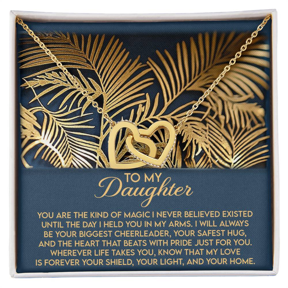 A gold Interlocking Hearts necklace with sparkling cubic zirconia, presented in a decorative box featuring palm leaf designs and a heartfelt message of love and support for a daughter.