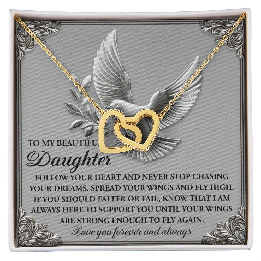 The Daughter-Your Wings Interlocking Hearts Necklace features a stunning 18k yellow gold finish with sparkling cubic zirconia crystals on a card with a dove illustration, offering a heartfelt message encouraging your daughter to follow her dreams and reassuring your support.