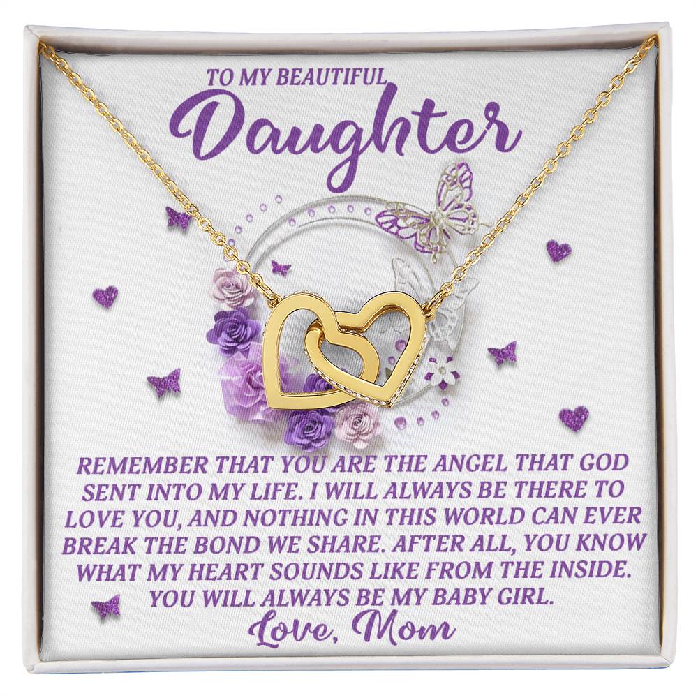 The Daughter-Angel Heart necklace features interlocking hearts adorned with sparkling cubic zirconia crystals, presented in a box saying, "To My Beautiful Daughter," surrounded by purple roses and butterflies, underscoring a mother's love and commitment.