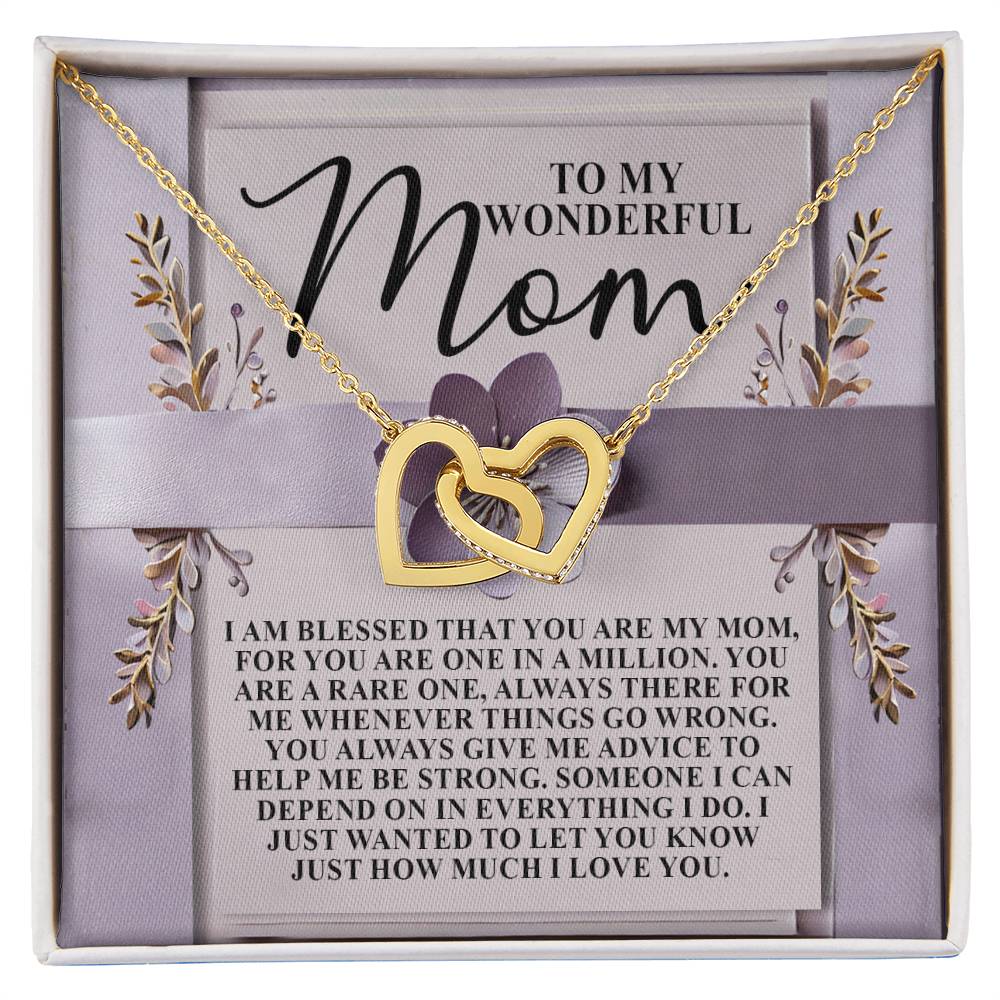 The Mom-Rare One - Interlocking Hearts Necklace features a gold heart with a rose gold finish, displayed on a floral-accented card. The card says "To my wonderful Mom," followed by a heartfelt message expressing love and gratitude.